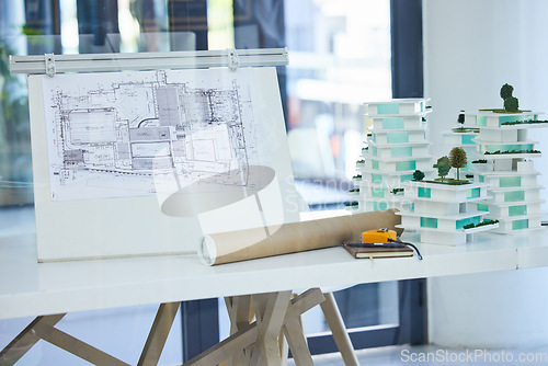 Image of Architecture, design and blueprints on an office desk with plans and a building model for the construction industry. Architect office, planning and equipment in a modern and creative workplace