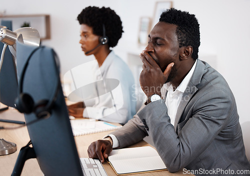 Image of Tired, burnout and exhausted business man, overworked sleepy and yawning in his call center office at work. Exhaustion and tiredness with a customer support agent or sales agent sitting at his desk