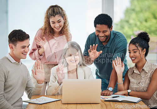 Image of Diversity, creative and corporate team on a video call while greeting a colleague on a laptop. Team waving at coworker on online zoom meeting. Business people networking on a webinar to do teamwork.