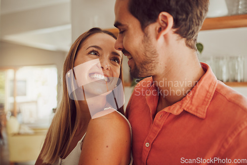 Image of Couple, smiling and in love having a lovely romantic moment in the kitchen at home. Man and woman spending affectionate free time together, happy and bonding with embraced happiness.