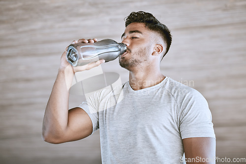 Image of Fitness runner after training, healthy drinking water from bottle and strong athletic young man takes a break from running. Workout motivation, wellness exercise and natural sports lifestyle