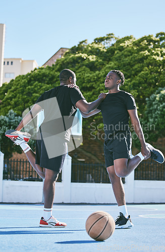 Image of Fit, active and sporty young basketball players stretch or warm up their legs on a basketball court. Determined male athletes prepare muscle fitness before practicing or training at a sports venue