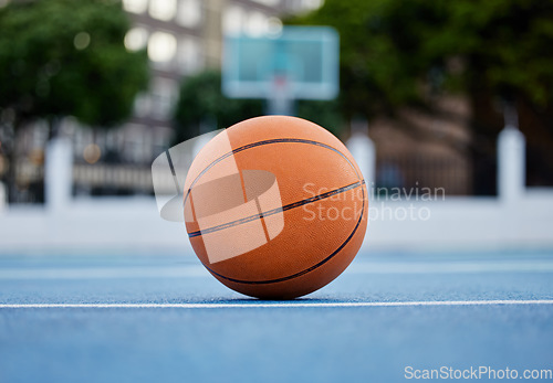 Image of Basketball on the floor of a sports court during training for a game in summer outdoors. Closeup of orange ball for athlete team to practice their strategy for fitness and exercise in outside stadium