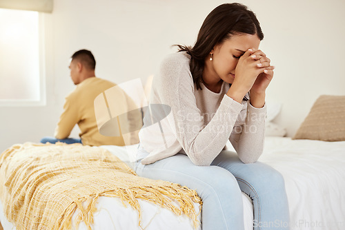Image of Uhappy, stressed and cheating while a couple sit on their bed feeling sad, upset and disappointed with sexual issues or communication problems. Heartbroken wife ignoring her partner after an argument