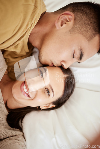 Image of Happy, smiling and affectionate young couple in love taking a selfie together in the bed at home. Portrait of loving female taking a photo in happiness while her partner is sleeping during the day.