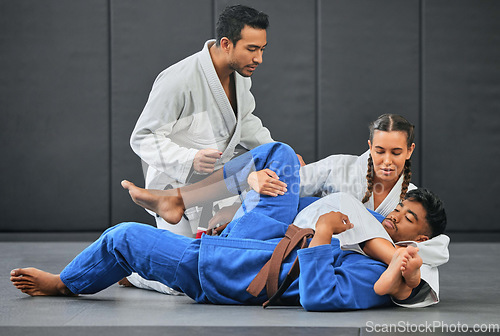 Image of Mma, martial arts and exercise with a coach, teacher or instructor instructing students during practice, training or sparring in a gym or dojo. Fighting and self defense class for health and fitness