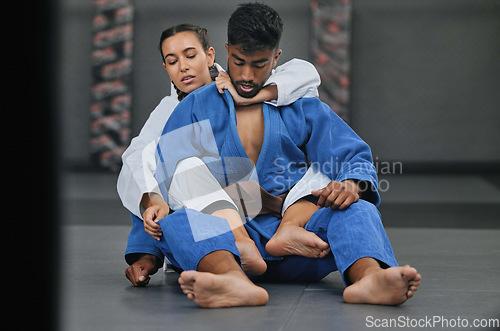 Image of Woman in karate fitness training class with coach, learning self defence in gym class and fighting male trainer at fight club. Man teaching a student martial arts, foot control and rear naked choke