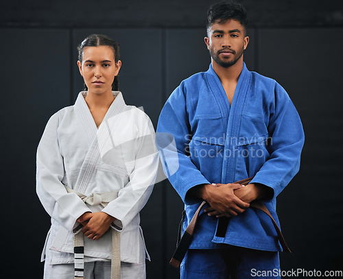 Image of .Fitness, motivation and discipline karate training with a student and teacher standing proud in a center or dojo. Young woman learning defense, strength and endurance lesson from martial arts coach.