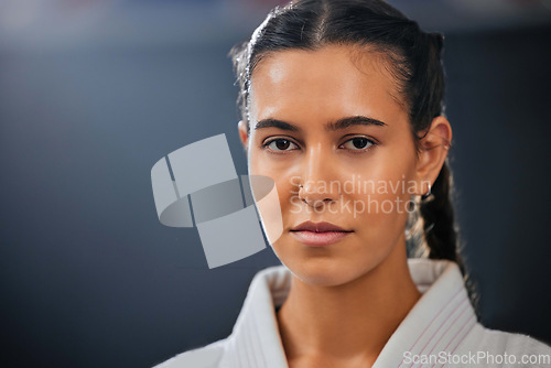 Image of Portrait of female athlete, serious, and in karate gear staring ahead. A young girl, healthy, with a determined and motivated face at martial arts training. Discipline, fight and fitness in the dojo.