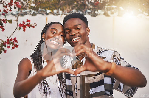 Image of Happy couple heart love sign with their hands posing for a picture or photo while on vacation or holiday. Portrait of a loving and young African American lovers having fun together smiling in joy