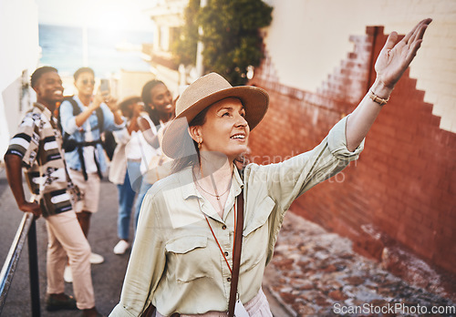 Image of Travel, education and a teacher with students on school field trip, on urban tour. Woman, city guide and group of happy tourists, pointing at local architecture and learning on international holiday.