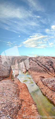 Image of Stream, water or inlet on rocky terrain outside under cloudy blue sky copyspace during summer. Nature, the wilderness and freedom on a sunny day for eco friendly environmentalism and conservation
