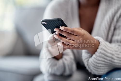 Image of Closeup of woman hands typing on phone, sending a text message online on social media on home sofa. Female reading and replying to a work email. African American lady playing a game on mobile device.