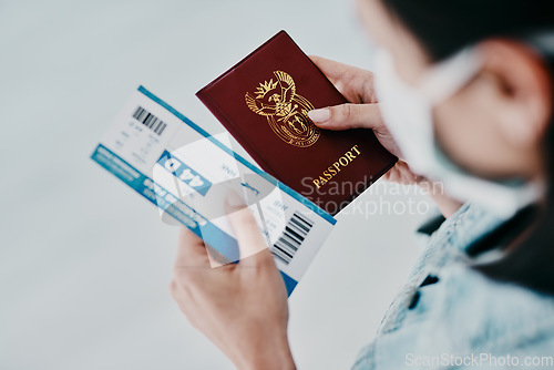 Image of Travel, covid and tourist visa or passport while holding a plane flight ticket with face mask at airport for immigration. Closeup of female traveler holding ID for traveling during corona pandemic