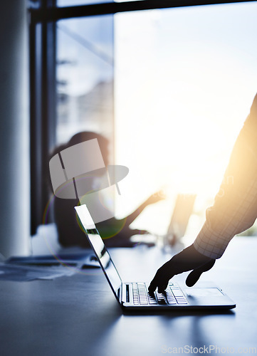 Image of Silhouette of the hand of a businessman working on a laptop in an office with sunlight and a blurred shadow of a woman in the background with bokeh. Outline of a male brainstorming in the office.