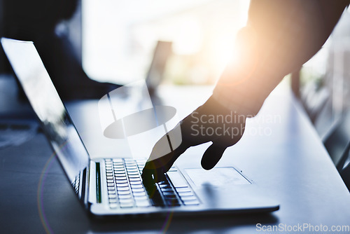 Image of Hand typing on a laptop during a business meeting in a dark office or boardroom. Closeup silhouette of a corporate professional using a computer and browsing the internet or sending an email