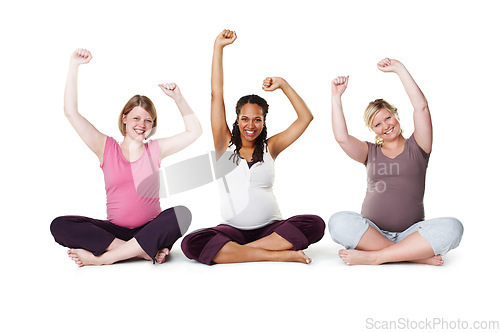 Image of Pregnant, happy, and healthy, women sitting on the floor, arms raised in celebration of new life. Mothers, friends, and happiness during pregnancy, a group of future moms workout on white background