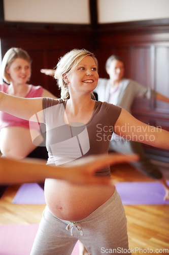 Image of Fitness, pregnant and wellness women in studio doing cardio exercise in pregnancy community for women. Happy mother to be with abdomen doing pilates or stretching with motivation smile in yoga class