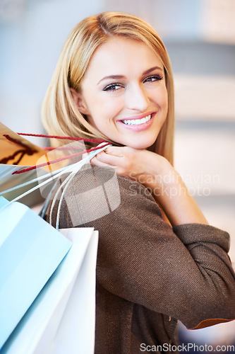 Image of Fashion, sale and shopping woman or customer is happy and excited holding bags at a store. Discount, offer and deal for smiling female in retail shop at the mall spending money on style at an outlet