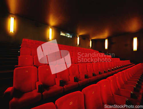 Image of Empty cinema or movie theatre with row of red seats at night before a movie or film theater interior room. Chair in a line with no audience after an event or show in auditorium or opera house