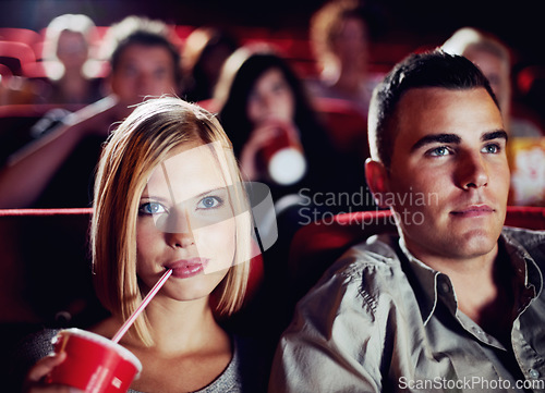 Image of Couple in dark movie theatre, drinking cola on date in cinema and man and woman watching a film together for entertainment. Face of happy, dating and fun boyfriend and girlfriend at the movies