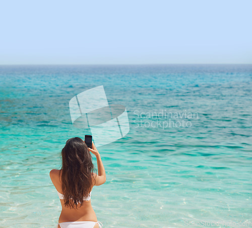 Image of Beautiful woman taking photos with smart phone technology on paradise beach destination summer wanderlust vacation