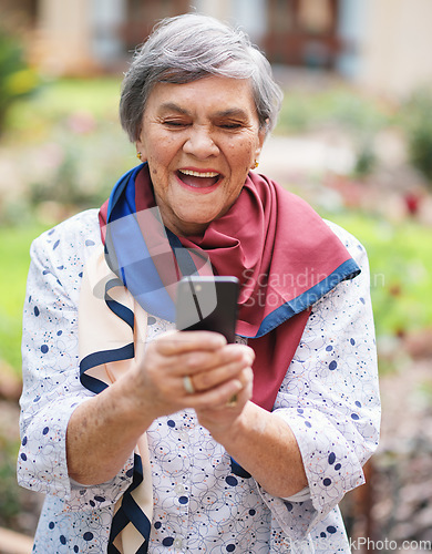 Image of Happy senior woman using smartphone texting browsing messages on mobile phone in beautiful garden