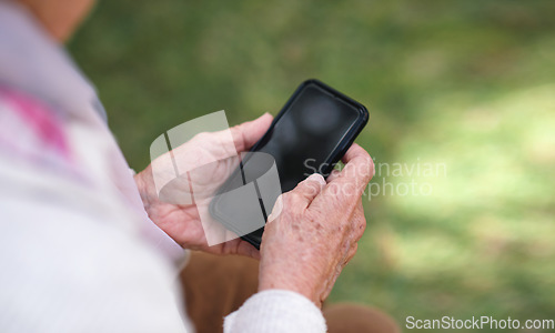 Image of Old woman hands using smartphone texting sending messages on mobile phone outdoors