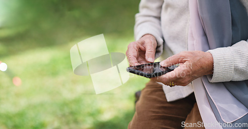 Image of Old woman hands using smartphone texting sending messages on mobile phone outdoors