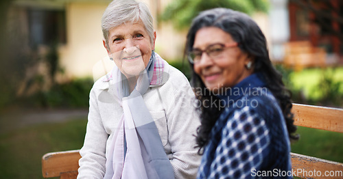 Image of Two old women sitting on bench in park smiling happy life long friends enjoying retirement together