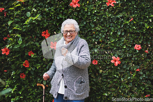 Image of Funny old woman dancing listening to music on smartphone wearing earphones smiling enjoying fun celebrating retirement in garden with flower wall