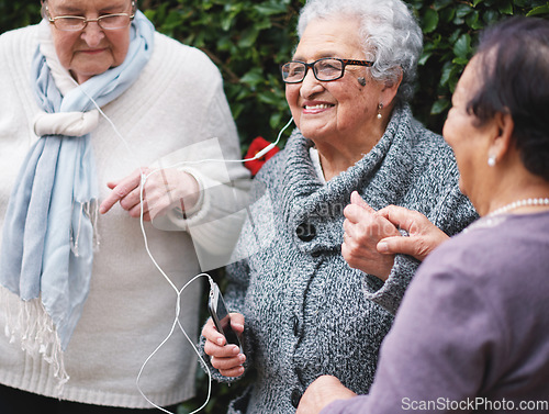 Image of Happy old women listening to music on smartphone wearing earphones smiling enjoying fun celebrating retirement together outdoors