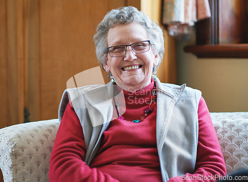 Image of Happy elderly woman smiling sitting on sofa at home enjoying retirement