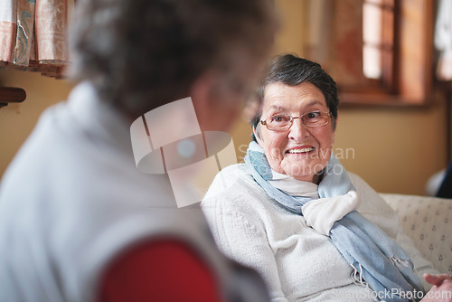 Image of Happy elderly woman talking to friend sitting on sofa in retirement home having conversation