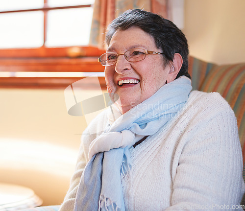 Image of Happy elderly woman laughing sitting on sofa at home enjoying retirement