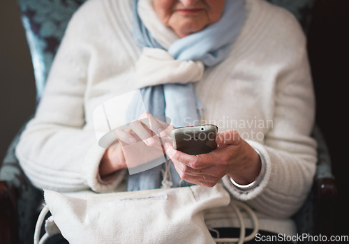 Image of Happy elderly woman using smartphone texting browsing on mobile phone sending messages sitting on couch at home