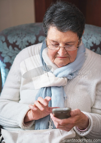 Image of Happy elderly woman using smartphone texting browsing on mobile phone sending messages sitting on couch at home