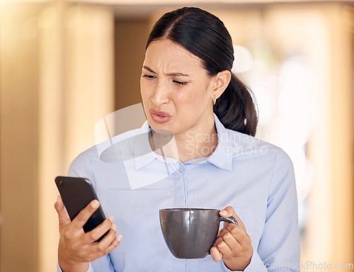 Image of Annoyed, confused and stressed woman on phone reading an article on an online website. Disgusted business lady browsing on social media or the internet with smartphone at office with cup of coffee.