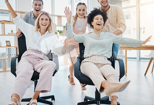 Image of Happy corporate colleagues having fun and being playful in an office, playing a game on chairs. Laughing friends silly and goofy, bonding and enjoying friendly team challenge after getting work done