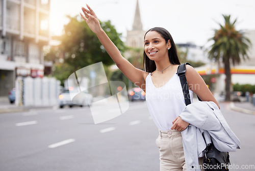 Image of Happy woman showing hand sign for a taxi while standing in a street in the city, business travel for a meeting or event. smiling female on her daily commute, gesture hail cab while on a trip downtown