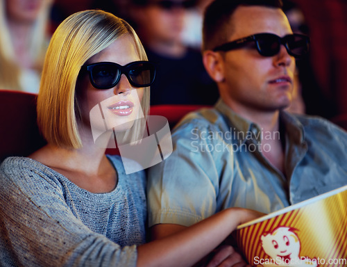 Image of Couple, 3D movie and cinema of a man and woman sitting and eating popcorn together wearing glasses. People in a relationship watching a film in a theatre for indoor entertainment while having snacks.