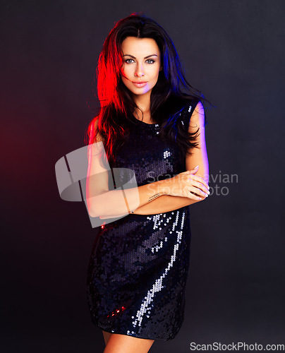 Image of Glamour, style and a confident woman looking cool in an evening dress against a dark, black background. Proud female standing in a power pose, feeling elegant and feminine with a party girl attitude