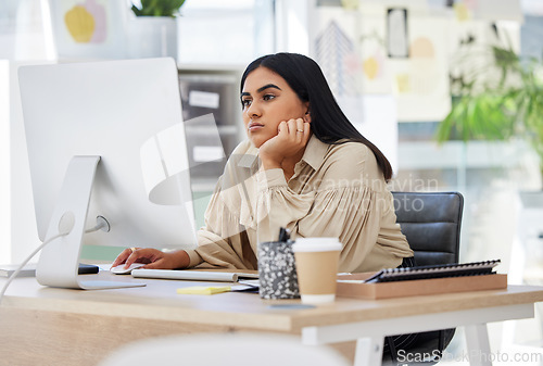 Image of A bored, lazy and tired employee working on a computer in the office leaning on her desk. An overworked business woman is annoyed and frustrated by her job sitting at her table feeling burnout