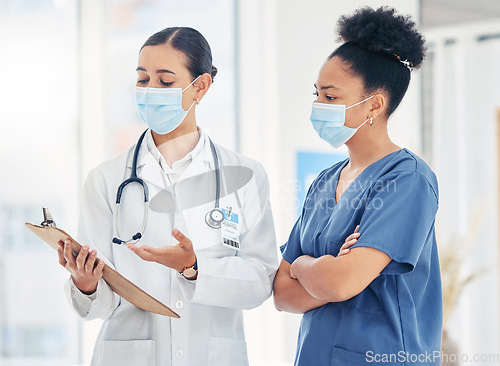 Image of Doctor and nurse reading medical information paperwork with mask for safety from covid or corona virus in a hospital. Healthcare workers discuss and analyze pandemic data report in a clinic together