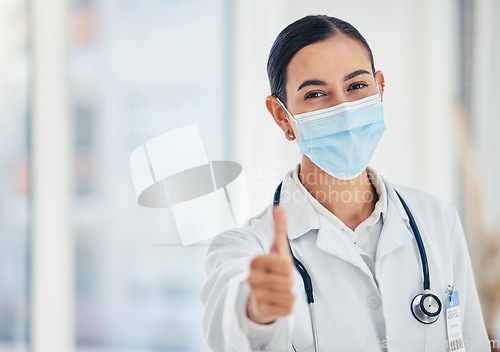 Image of Thumbs up, mask portrait and doctor in agreement with healthcare procedure at hospital. Woman medical worker with yes hand gesture for satisfaction with safety protocol at care facility.