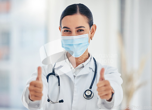 Image of Covid, portrait and thumbs up doctor with mask happy with hospital hygiene for infection safety. Healthcare woman with hand gesture of success for virus prevention in consultation room.