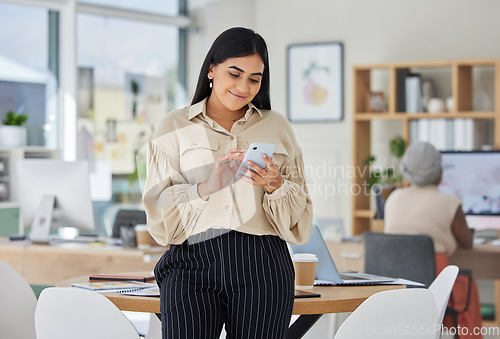 Image of Entrepreneur on phone with social media online in a modern office. Business woman smile while chatting and checking email at work or sharing good news of a successful startup with a mobile smartphone