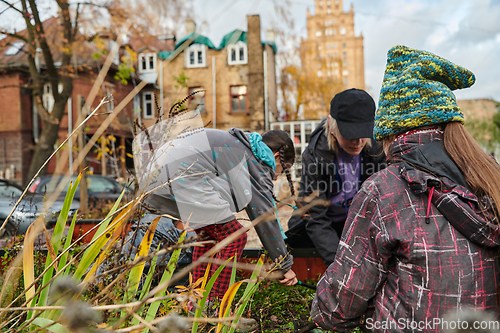 Image of A modern family parents and children, is working together to beautify their front yard with flowers in preparation for the upcoming holiday season.