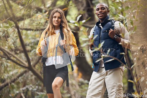 Image of Portrait of interracial couple hiking in a nature forest environment or woods together in spring. Man and woman walking in sustainable outdoor ecology during trekking adventure or travel on holiday