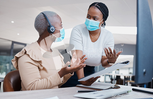 Image of Manager consulting a call center agent about business paperwork with face masks in covid pandemic. Black, young and customer support worker discussing a work mistake with her mentor in an office.